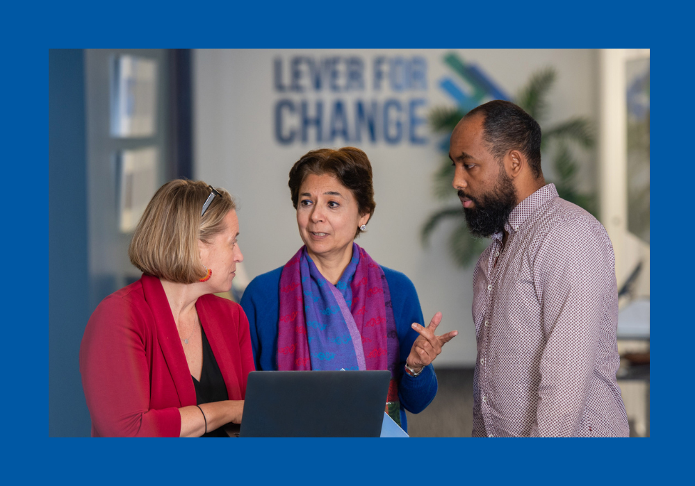 Photograph of Kristen Molyneaux, PhD, speaking with team members